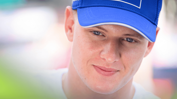 A close-up shot of Mick Schumacher smiling thinly at the 2022 Monaco Grand Prix