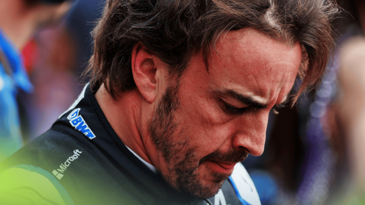A close-up shot of Fernando Alonso with his head lowered on the grid at the 2022 Mexican Grand Prix