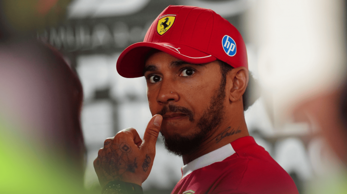 Lewis Hamilton holds his hand to his mouth in the media pen at Imola