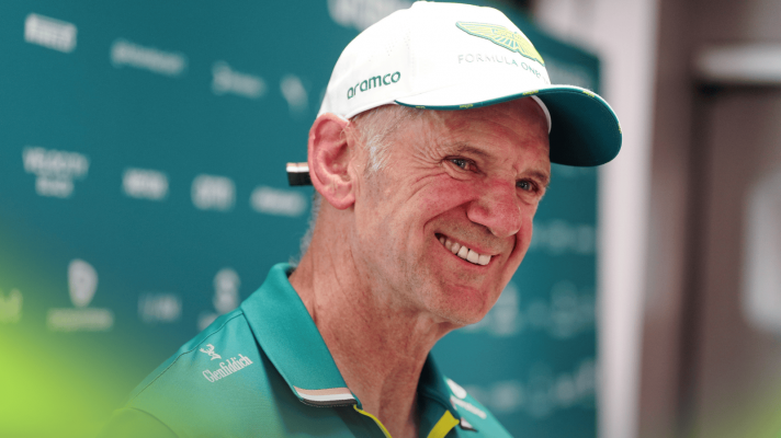 Adrian Newey smiles while wearing Aston Martin team kit