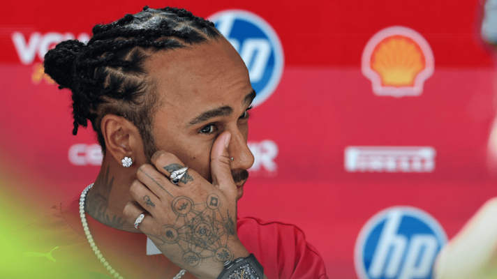 Lewis Hamilton touches his face as he faces the media in Monaco