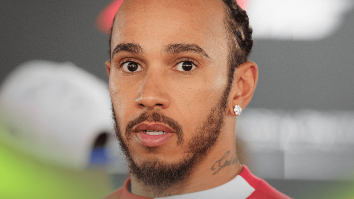 Lewis Hamilton eyes the camera while facing the media