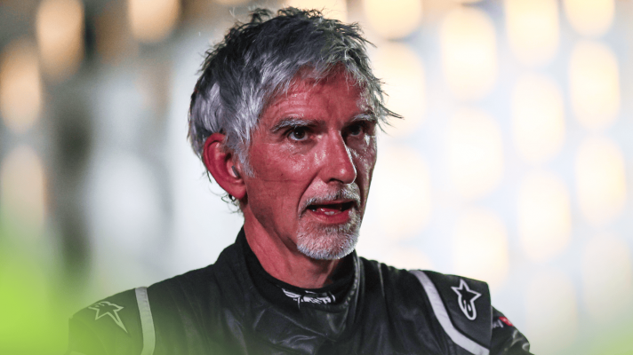 Damon Hill looks exhausted while wearing racing overalls