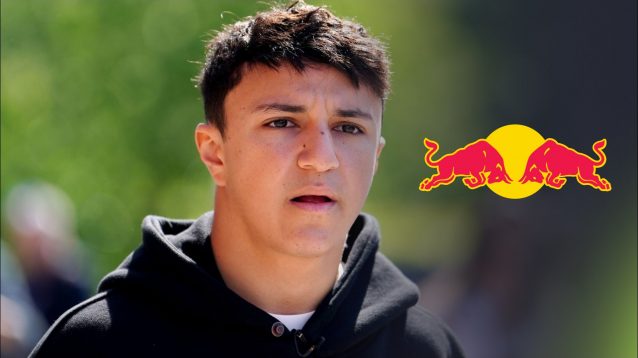 Isack Hadjar pictured at the 2025 Emilia Romagna Grand Prix, with a Red Bull logo to his right