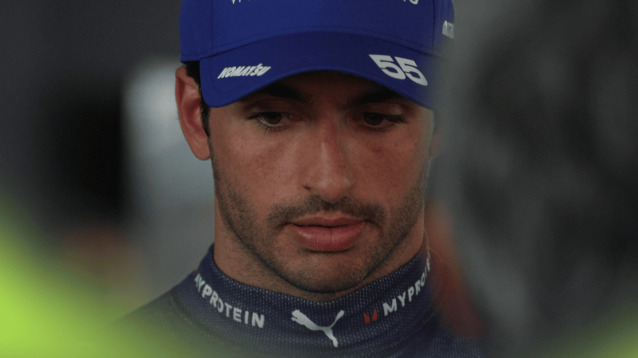 Carlos Sainz looks downbeat as he faces the media