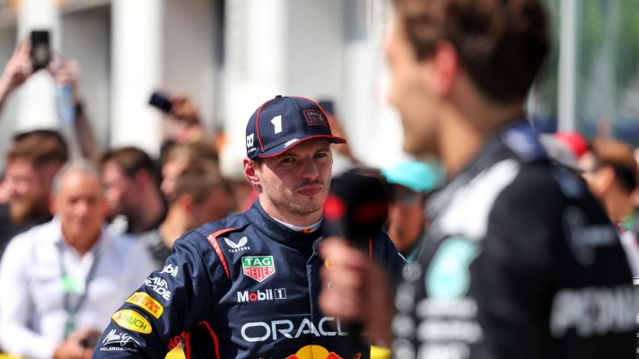 Second placed Max Verstappen looks on as Canadian GP winner George Russell is interviewed.