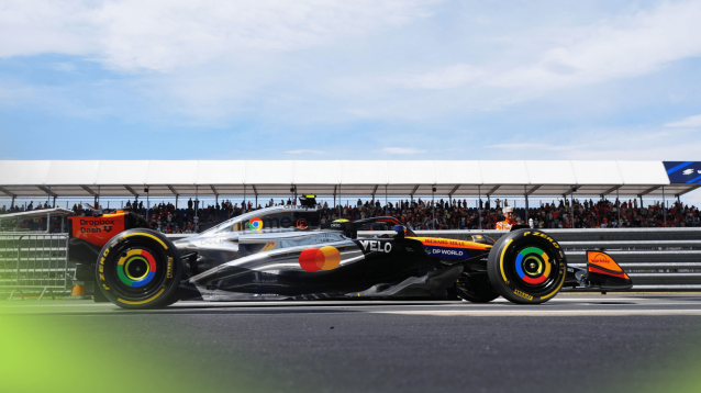 A ground-level shot of Lando Norris entering the pit lane at Silverstone