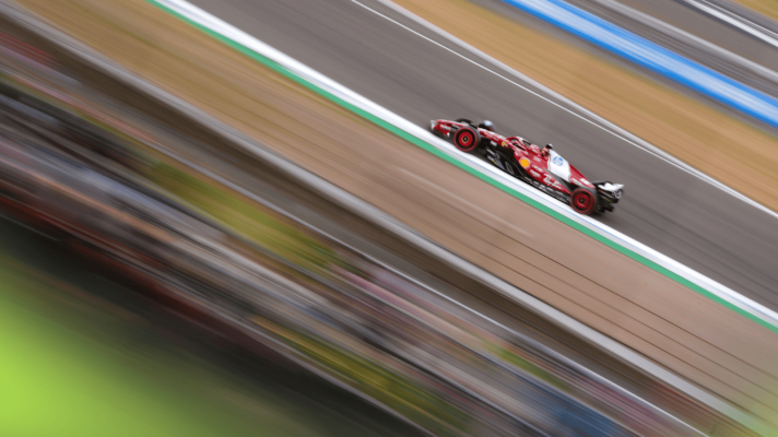An action shot of Charles Leclerc on track at Silverstone with a blur effect to give a sensation of speed