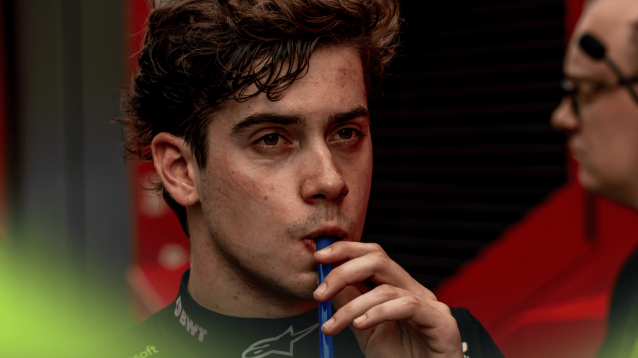 Franco Colapinto sucks from a straw in the F1 paddock in Austria