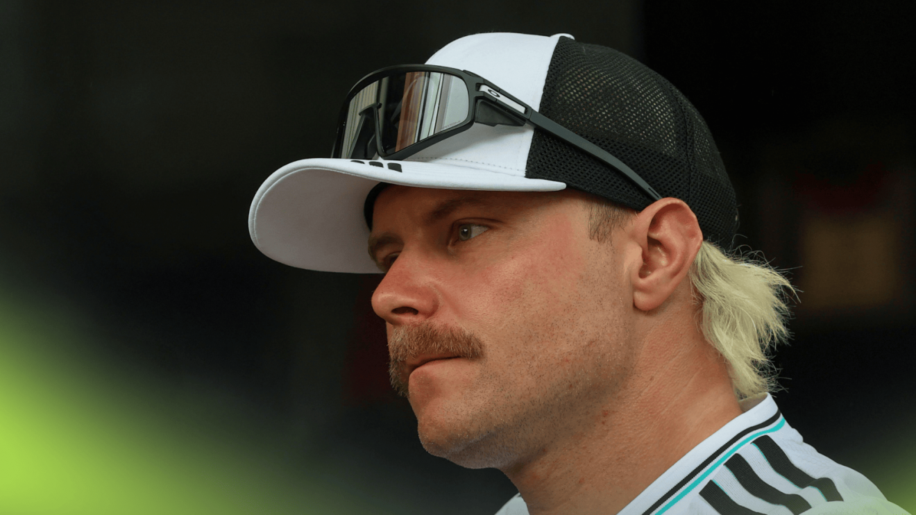 Valtteri Bottas looks on while wearing Mercedes team kit in the paddock
