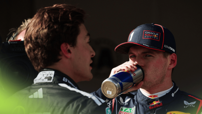 Max Verstappen eyes George Russell as he drinks from a Red Bull can in parc ferme