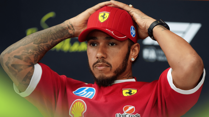Lewis Hamilton holds his hands on the back of his head in a press conference