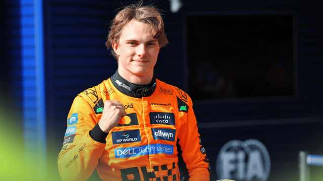 Oscar Piastri punches the air as he eyes the camera in parc ferme at Spa