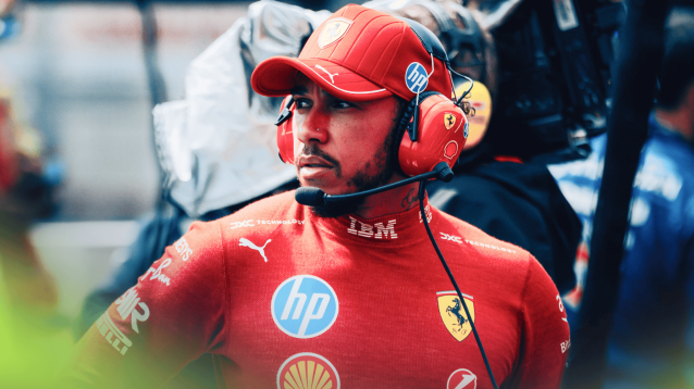 Lewis Hamilton looks on as he wears a set of Ferrari headphones over his cap in the Spa pit lane