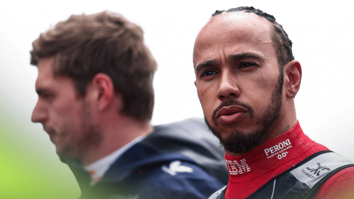 Lewis Hamilton puffs out his cheeks during the national anthem at Silverstone as Max Verstappen looks on