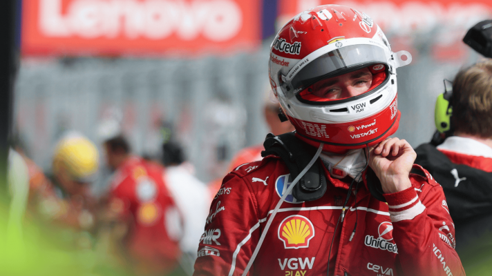 Charles Leclerc unfastens his helmet in parc ferme in Hungary with Lewis Hamilton in the background