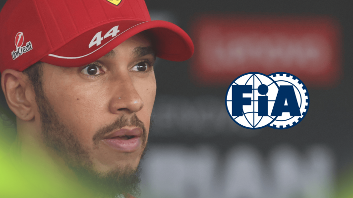 A close-up shot of a wide-eyed Lewis Hamilton with a prominent FIA logo alongside him