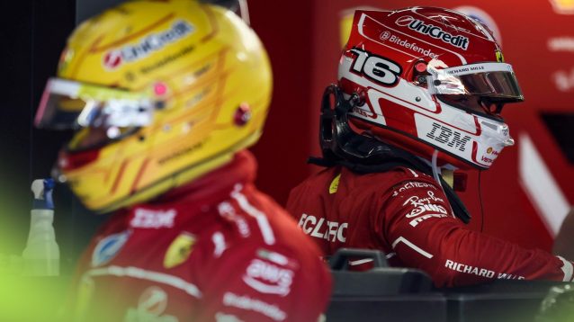 Ferrari drivers Lewis Hamilton and Charles Leclerc, in their race gear, pictured on either side of the garage at the 2025 Austrian Grand Prix
