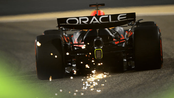 A rear-facing shot of Max Verstappen's Red Bull RB21 kicking up a shower of sparks in Bahrain