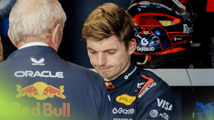 Max Verstappen looks disappointed with his head lowered while in conversation with Helmut Marko in the Red Bull garage