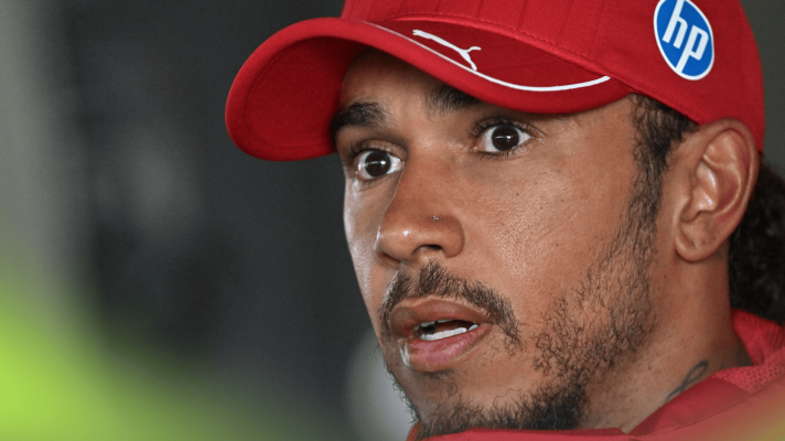 Lewis Hamilton looks wide-eyed and open mouthed while facing the media