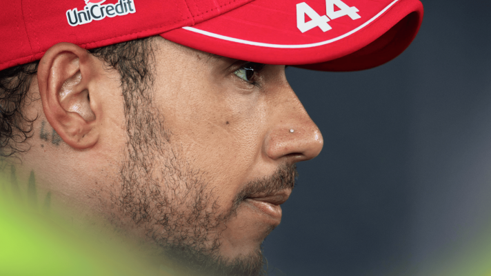 A side-profile shot of Lewis Hamilton wearing a Ferrari cap