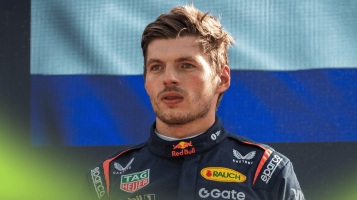 Max Verstappen looks on from the media at Monza with a Dutch flag in the background