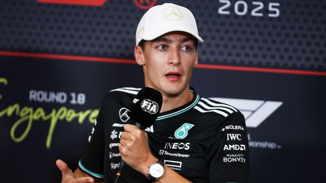 George Russell speaking into a microphone