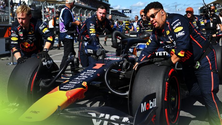 A group of Red Bull mechanics wheel Max Verstappen's car towards his grid slot in Austin
