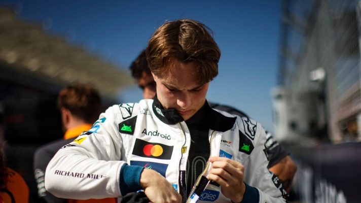 Oscar Piastri looks down as he zips up his race suit on the grid in Austin