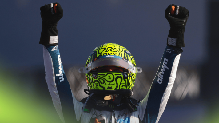 Lando Norris raises his arms aloft in celebration