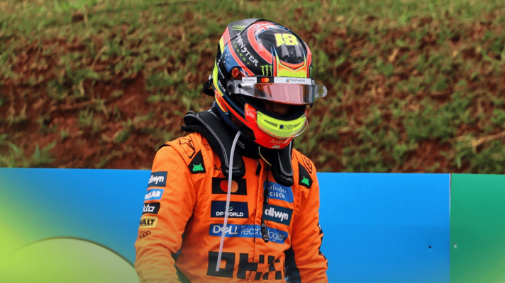 Oscar Piastri walking away from his accident in the Brazil sprint race with his helmet visor partially open