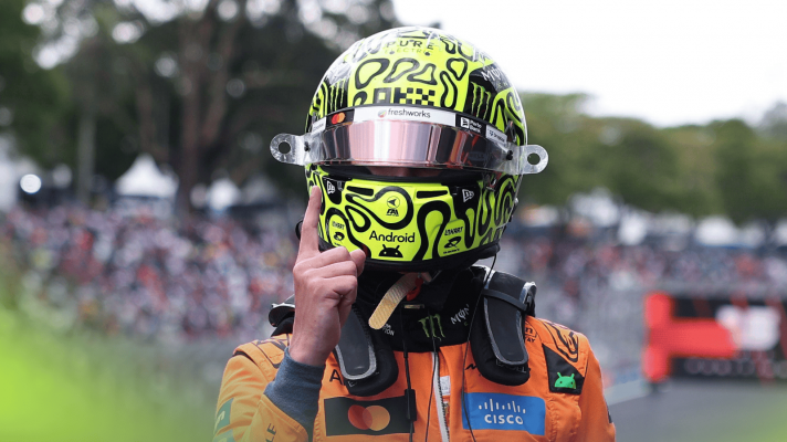 Lando Norris holds his finger in the air in celebration in parc ferme