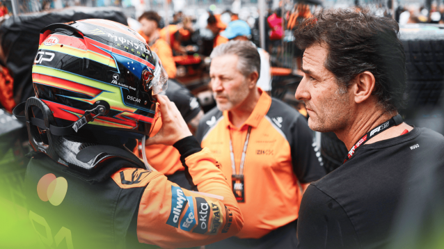 Oscar Piastri puts on his helmet on the grid as Mark Webber looks on with Zak Brown positioned in the middle