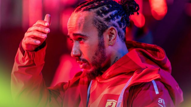 Lewis Hamilton, Ferrari, lifts his hand to shield his eyes at the 2025 Las Vegas Grand Prix