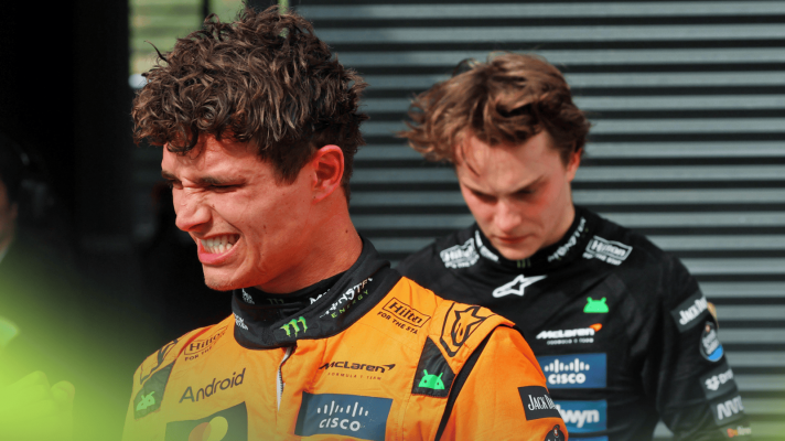 Lando Norris grits his teeth as he celebrates in parc ferme in Hungary with Oscar Piastri in the background