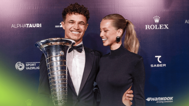 Lando Norris smiles broadly with his partner Margarida Corceiro after collecting the F1 world championship trophy