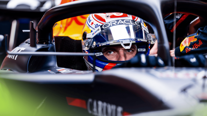 Max Verstappen sitting in the cockpit of his Red Bull RB21 with his visor open