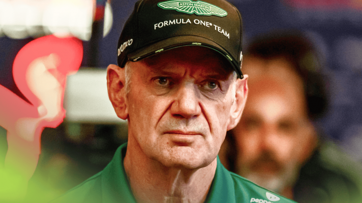 Adrian Newey looks into the middle distance while wearing Aston Martin uniform in the paddock