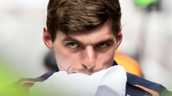 Max Verstappen looks on angrily as he wipes his face with a towel