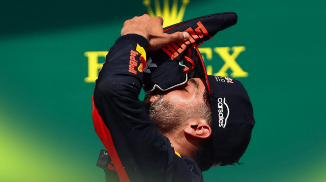 A side-profile shot of Daniel Ricciardo drinking from his shoe on the podium
