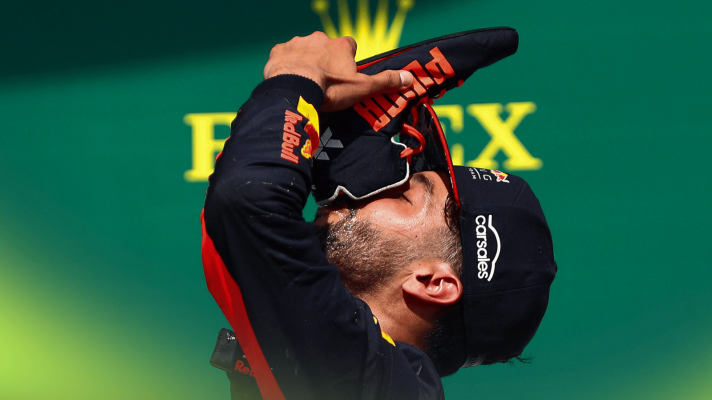 A side-profile shot of Daniel Ricciardo drinking from his shoe on the podium