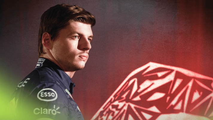 Max Verstappen looks on as he poses next to a glowing Red Bull logo