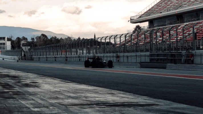 The Audi F1 2026 car making its way down a darkly lit Barcelona pit lane