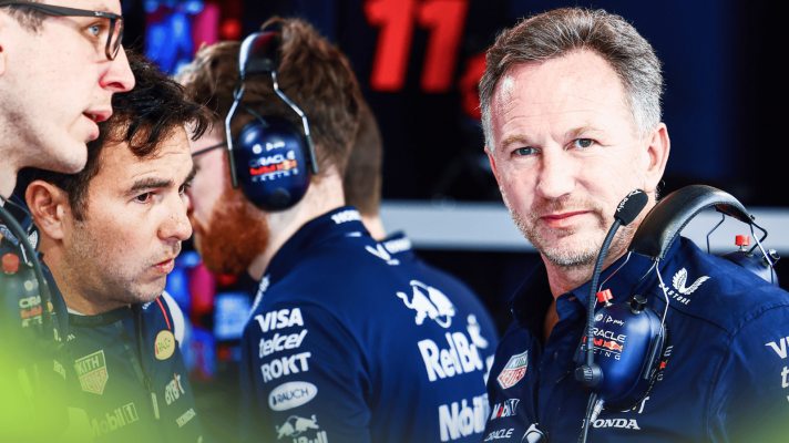 Christian Horner eyes the camera in the Red Bull garage as a worried Sergio Perez looks on