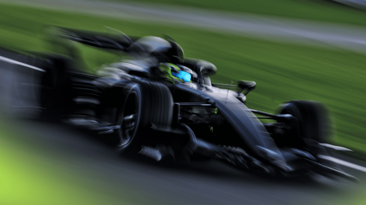 A blurry image of Sergio Perez driving the Cadillac F1 car at Silverstone