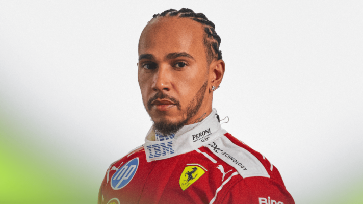 A portrait shot of Lewis Hamilton posing in Ferrari's 2026 race overalls against a white background