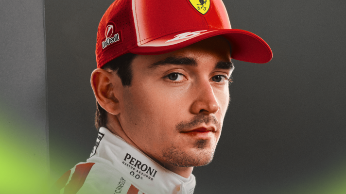 A close-up shot of Charles Leclerc modelling Ferrari's new race overalls and cap