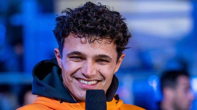 Lando Norris smiles in the paddock.