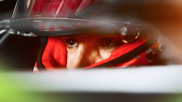 A close-up shot of Esteban Ocon's eyes visible through the open visor of his helmet